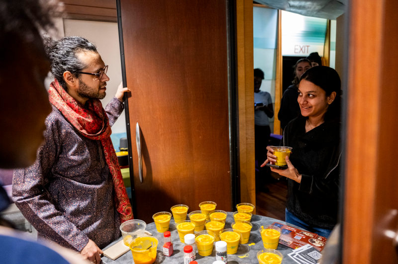 A staff member hands out mango milk to a participant during Northeastern University's Wellness Week.