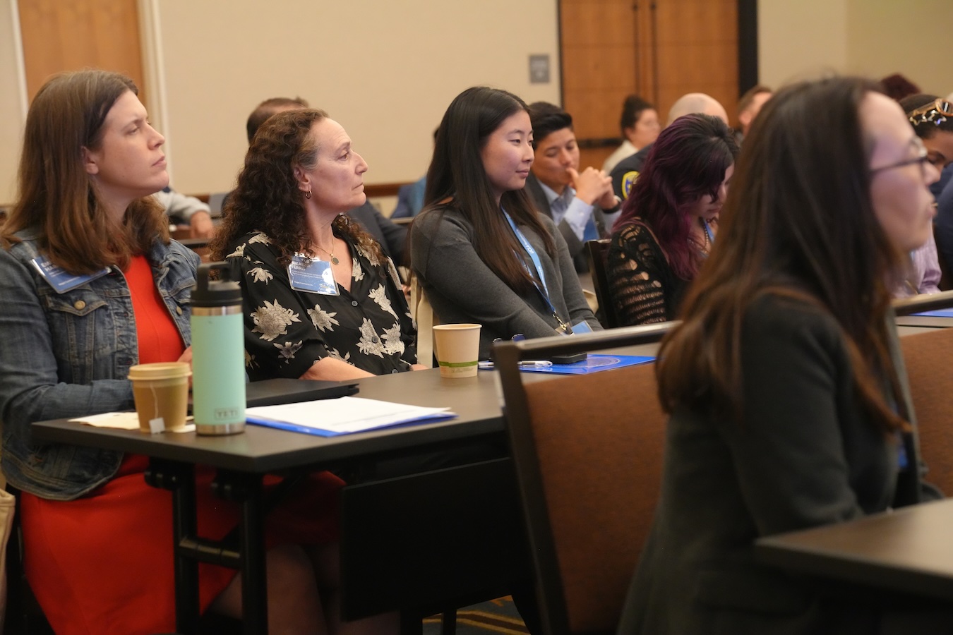 Hope Connects Us - Four participants sitting at a table listening to a presentation