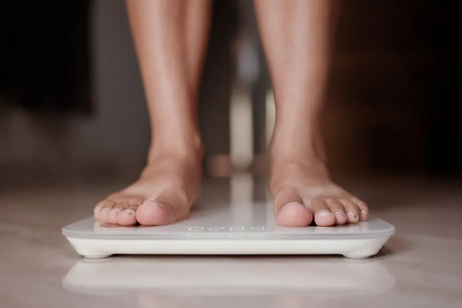 Woman checks weight loss on scale