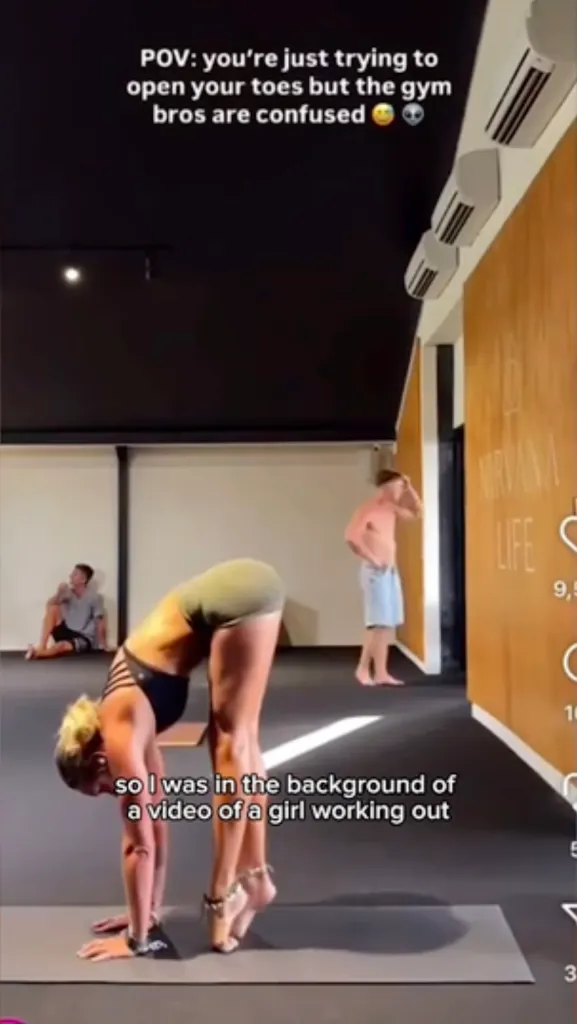 A woman stands in a gymnasium while two men watch.