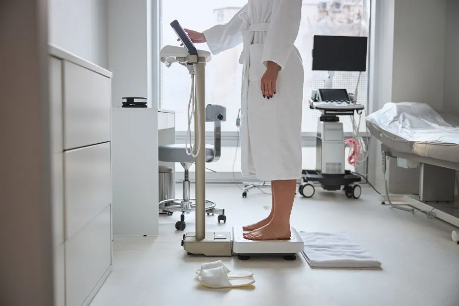 Woman checks metabolic health on body weight scale